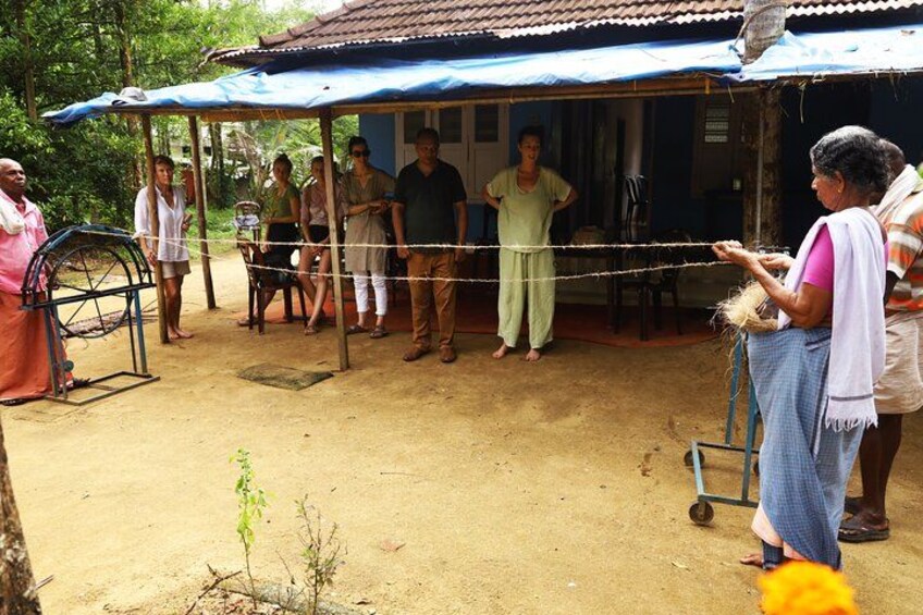 A group of people gathered under a blue-roofed structure in a rural setting. 3