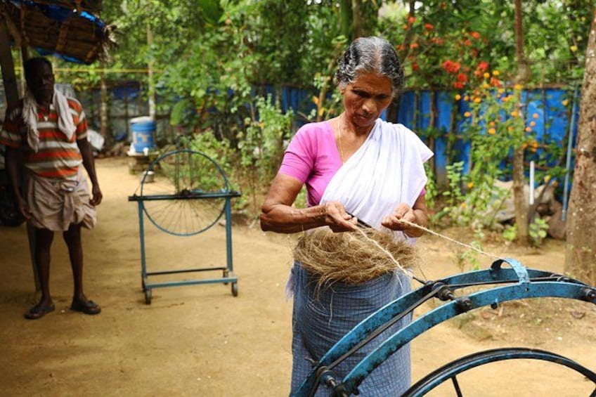 A person weaving with a basket of materials, a blue bicycle, and a man standing in the background. 4