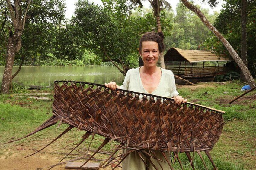 A person holding a woven basket in a natural setting with trees and a pond. 4