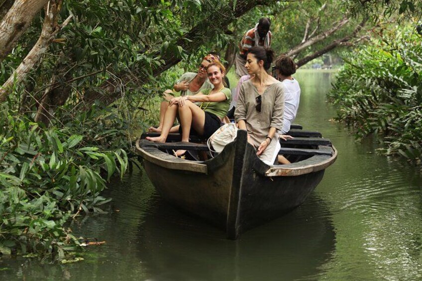 A small boat with people on a river surrounded by dense greenery. 2