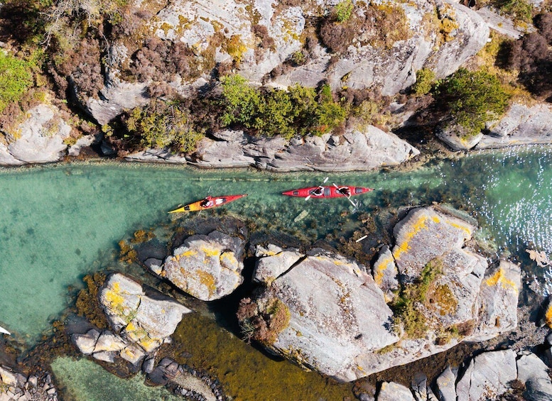 Two kayaks on a clear river surrounded by rocky terrain. 5