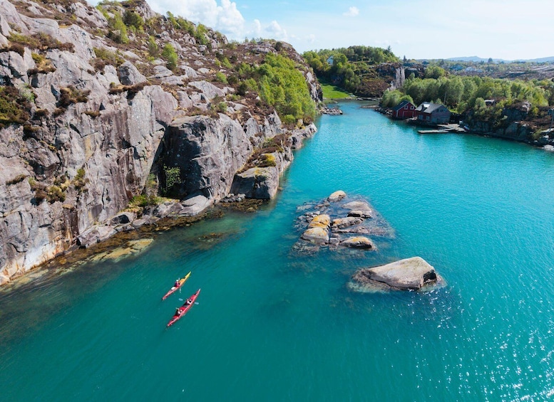 A river with kayaks, rocky cliffs, and a small settlement. 4