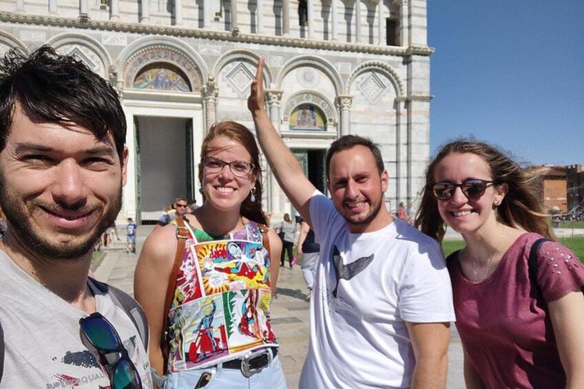 Un grupo de personas frente a un edificio histórico con arcos y columnas. 1