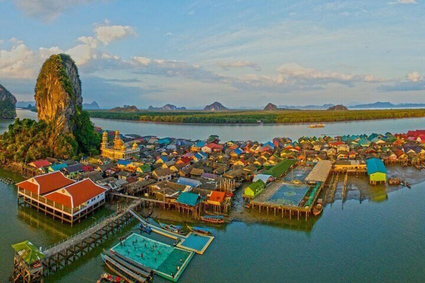 A floating village with colorful houses and a large rock formation in the background. 5