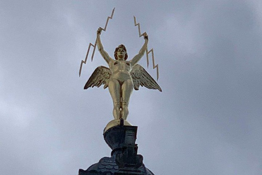 A statue of a winged figure holding lightning bolts. 3