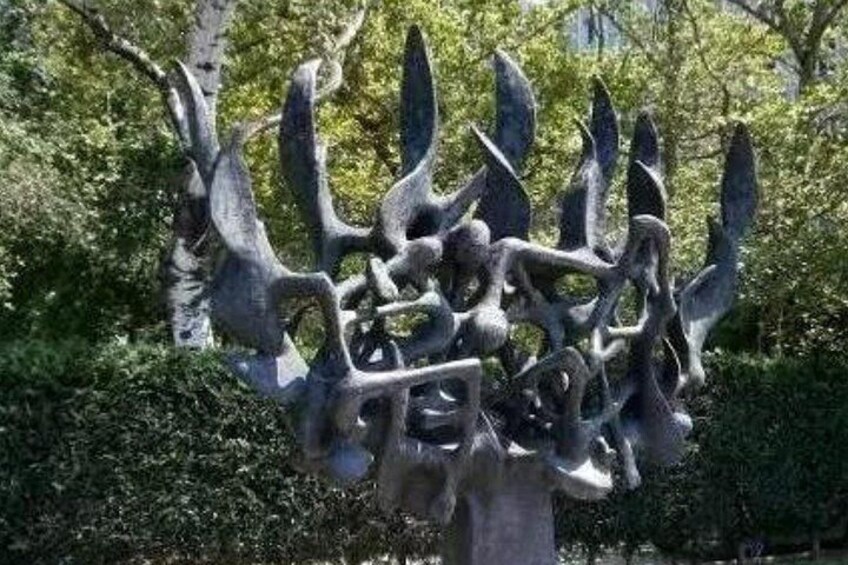 En skulptur af et træ med abstrakte, snoede grene og blade. 1