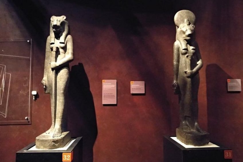 Two ancient statues on pedestals in a museum. 4