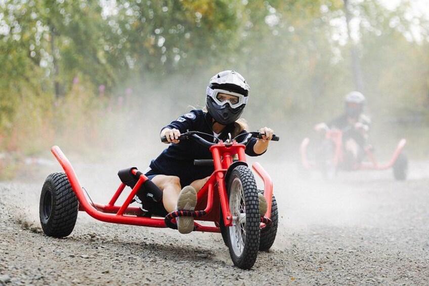 Et barn cykler på en grussti med træer i baggrunden. 4