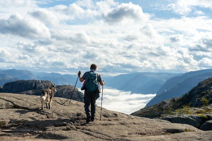 En vandrer med hund på en stenig sti med et bjergrigt landskab i baggrunden. 5