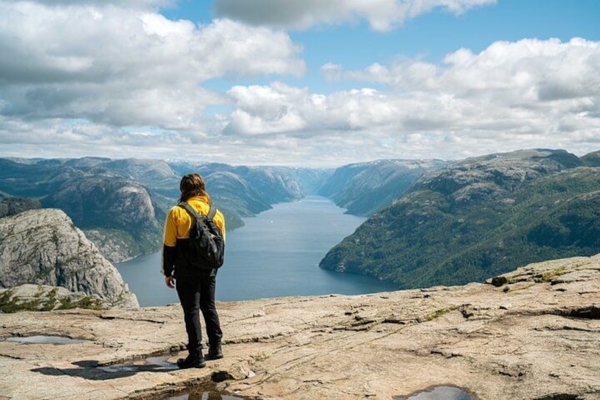 En person står på en klippe med udsigt over en sø omgivet af bjerge. 3