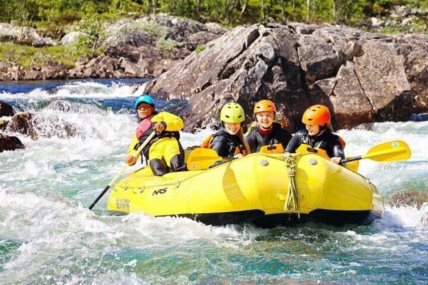 A group of people in a yellow raft navigating a river with rapids. 2