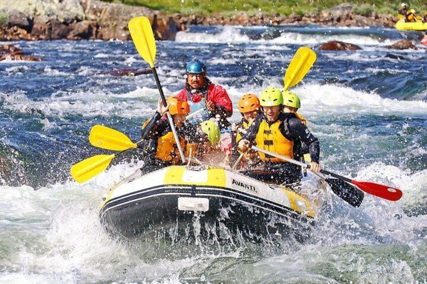 A group of people in a raft navigating through a river with rapids. 5