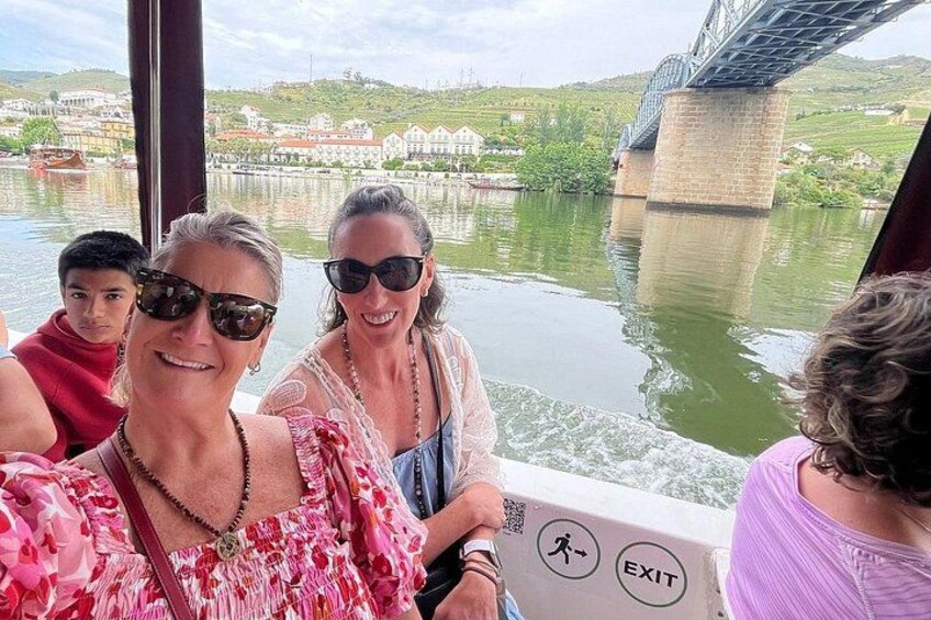 A group of people on a boat with a bridge and water in the background. 5