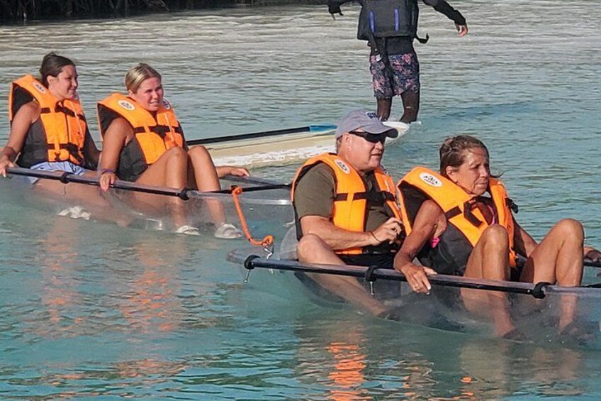 People in a boat on a body of water wearing life jackets. 3