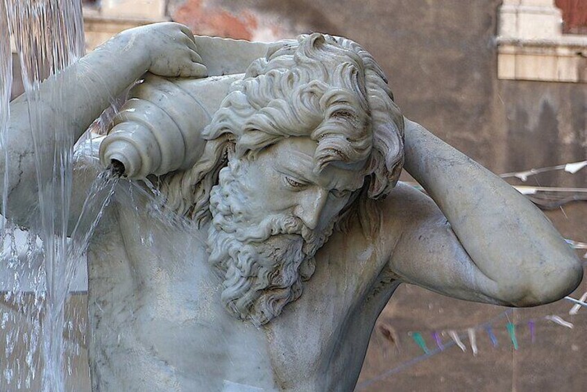 Una estatua de mármol de un hombre con barba y agua cayendo de la cabeza. 4