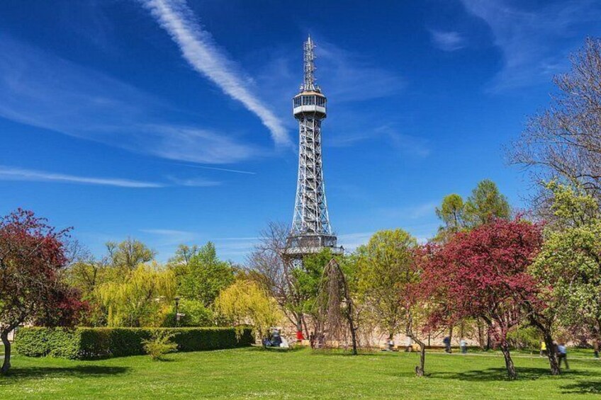The Eiffel Tower, surrounded by trees with autumn foliage, under a clear blue sky. 1