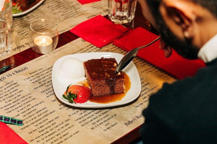 A dessert plate with a piece of cake and a strawberry on a menu. 4