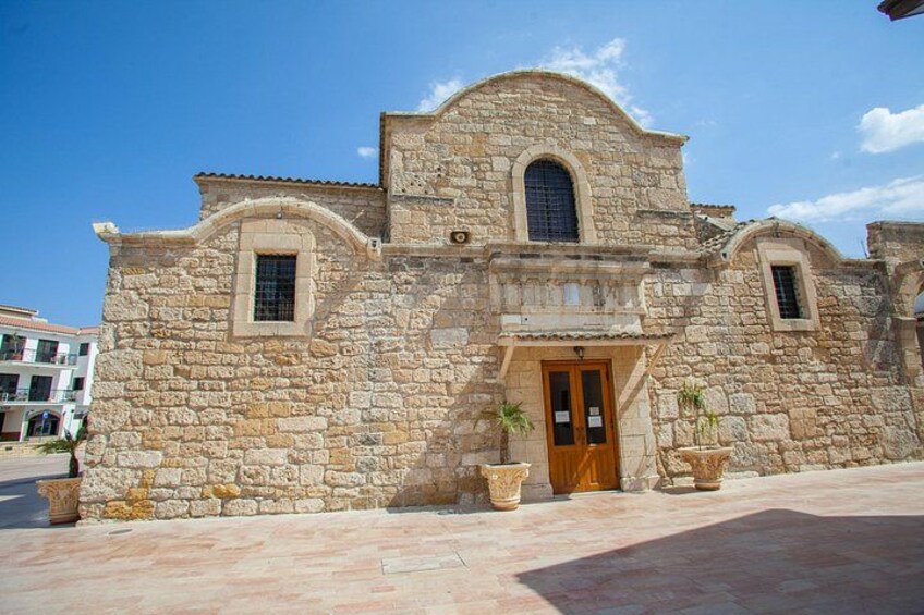 A stone building with a wooden door, arched windows, and a tiled roof. 3