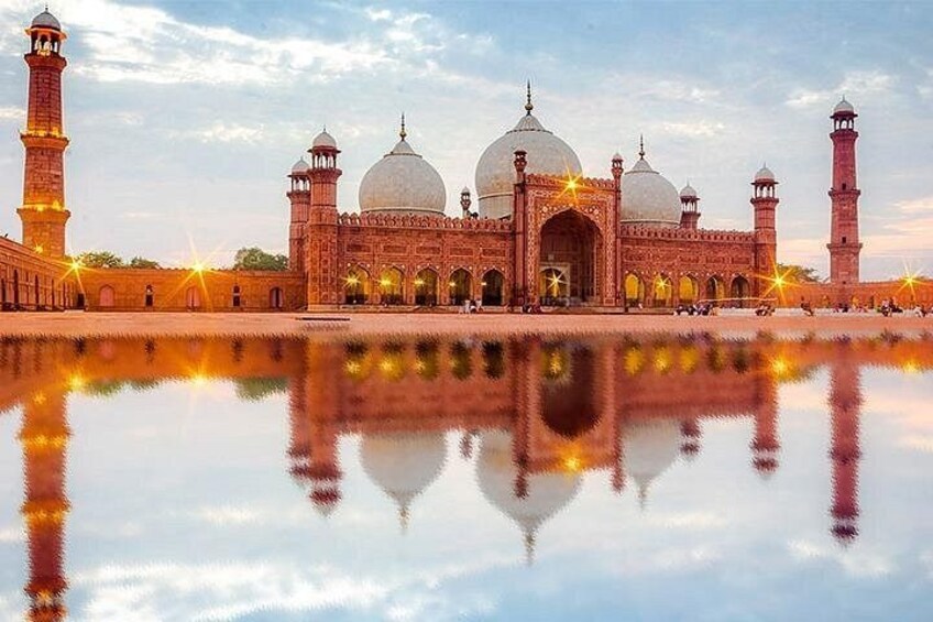 A large, ornate building with domes and minarets, reflecting in a calm body of water. 1