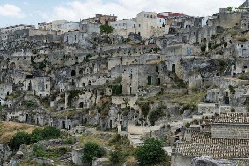 A densely built hillside with ancient ruins and modern buildings. 5