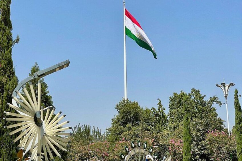 A flagpole with a flag, a sundial, and a decorative gate. 2