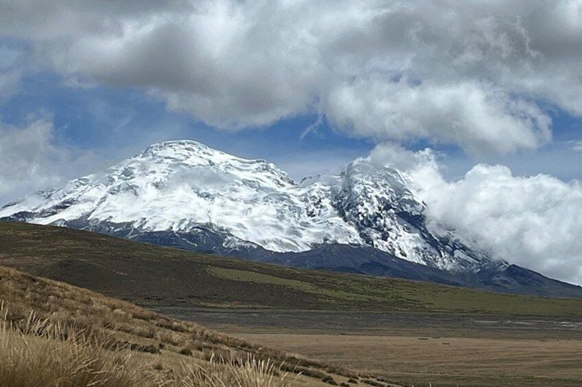 Une montagne aux sommets enneigés, de vastes plaines verdoyantes et un ciel partiellement nuageux. 3
