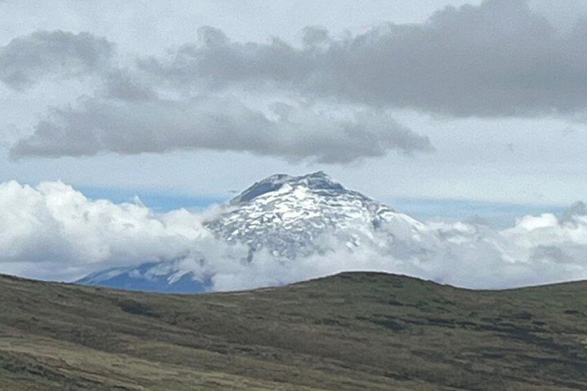 Une montagne enneigée, avec des nuages et un paysage verdoyant au premier plan. 4
