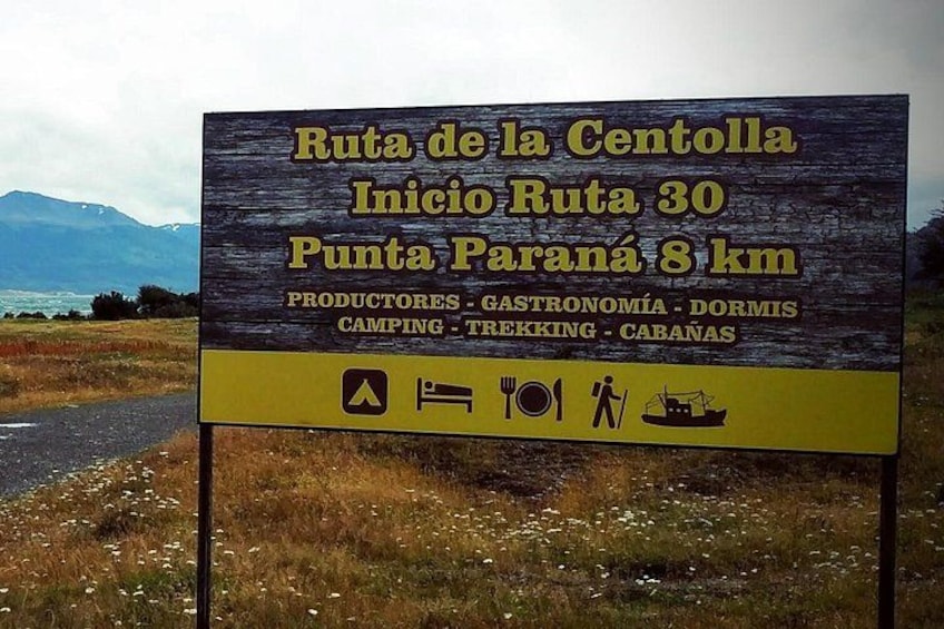 A sign for Ruta de la Centolla, indicating the start of Ruta 30 at Punta Parana 8 km. It lists activities like camping, trekking, and cabins. 2