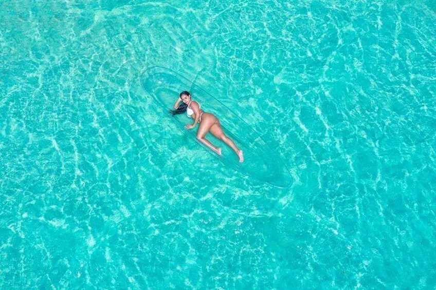 A person floating on a clear blue pool. 4