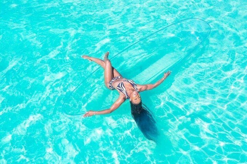 A person floating on a clear blue pool. 2