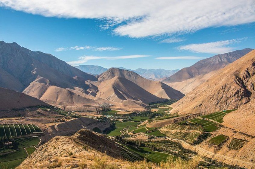 Un paisaje montañoso con campos en terrazas y un valle. 1
