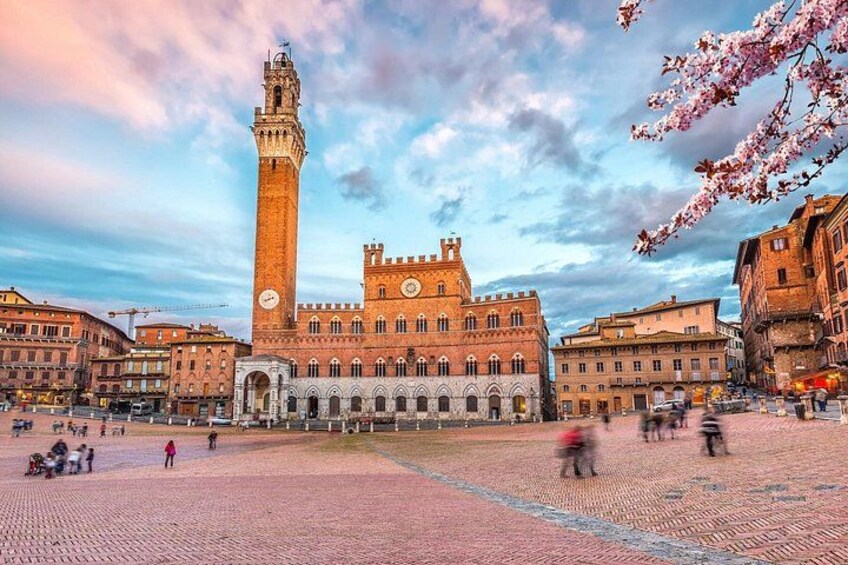 Una piazza storica con un'imponente torre dell'orologio e un edificio in stile rinascimentale. 2