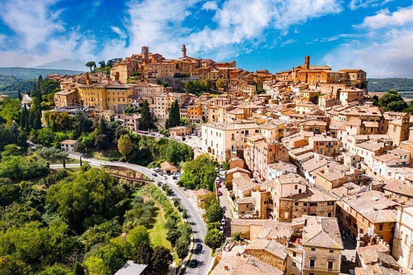 Una cittadina storica con un castello imponente su una collina, edifici medievali fitti e una strada tortuosa. 5