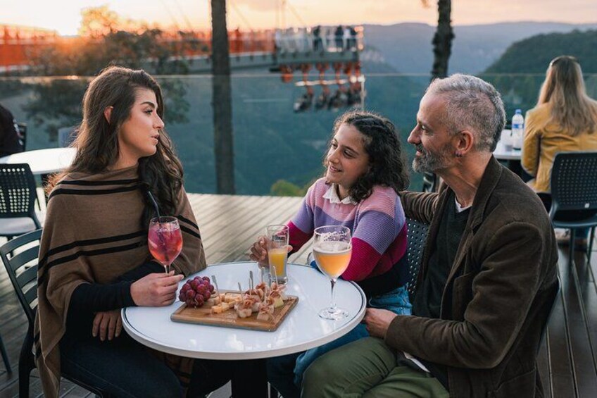 Un grupo de personas cenando al aire libre con una vista panorámica al fondo. 2