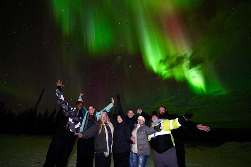 A group of people posing under the aurora borealis. 3