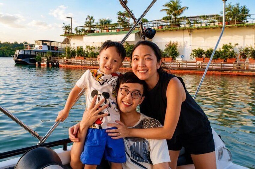A family on a boat with a bridge and palm trees in the background. 5