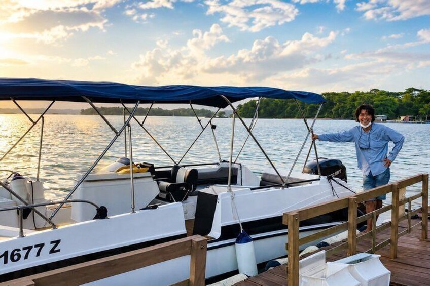 A sailboat docked at a pier with a person standing on the deck. 3