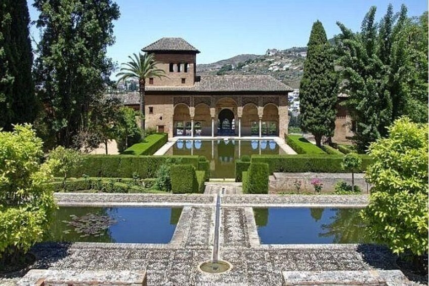 A historic building with a courtyard, a fountain, and well-manicured gardens. 3