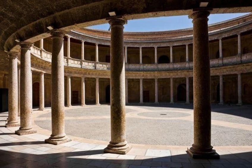 A circular courtyard with columns, a central open space, and a multi-tiered structure in the background. 5