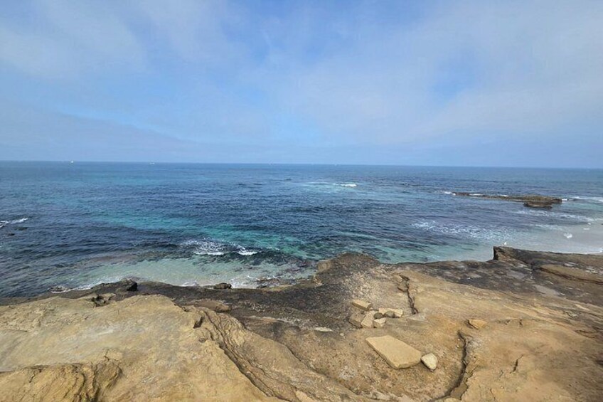 A coastal landscape with rocky terrain and the ocean. 4