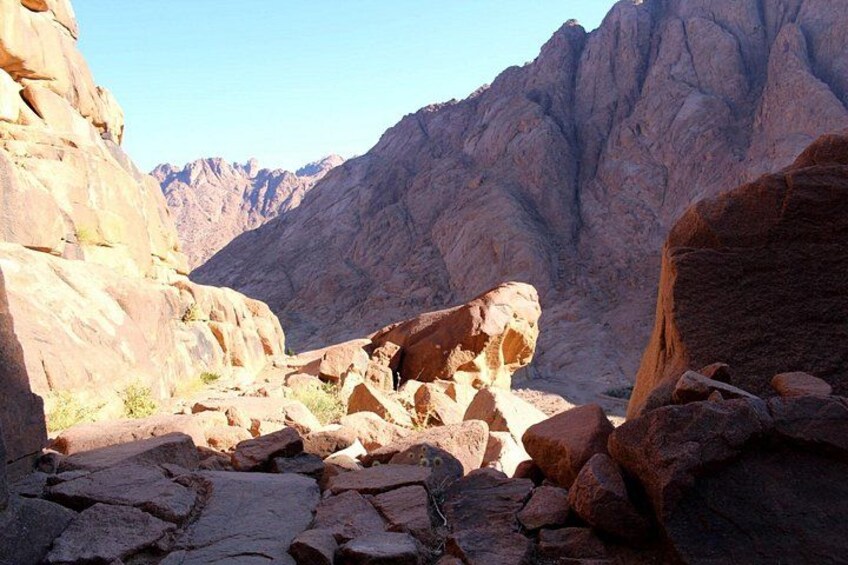 A rocky canyon with large boulders and steep cliffs. 3