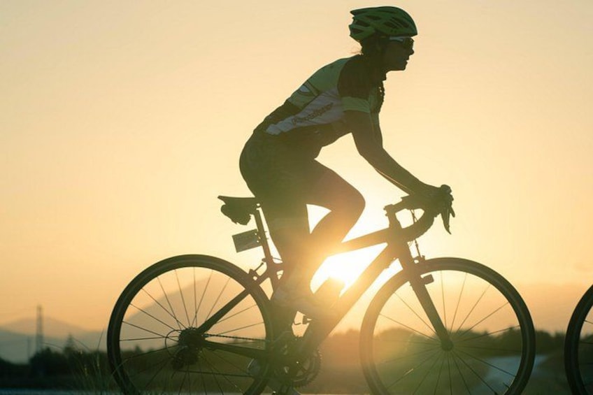 Un cycliste, dont la silhouette se détache sur le ciel au coucher du soleil, est en train de faire du vélo. 4