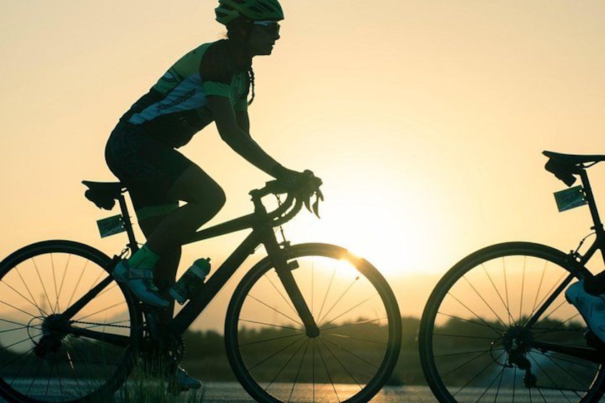 Un cycliste à vélo au coucher du soleil. 3