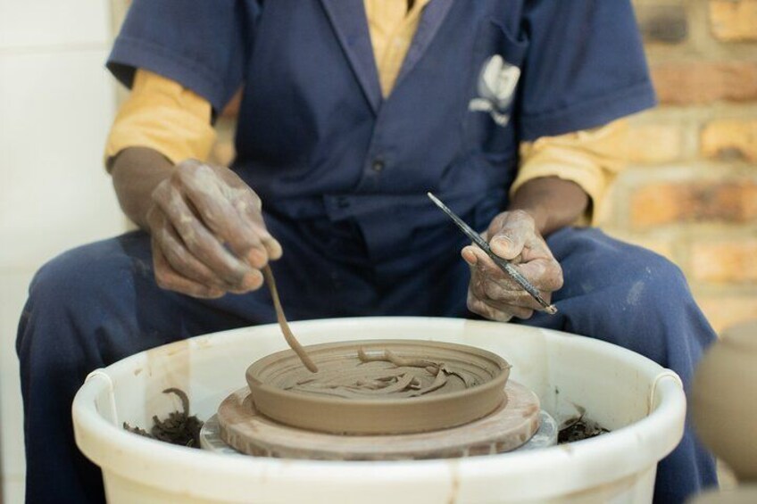 Una persona modelando arcilla en un torno de alfarería. 5
