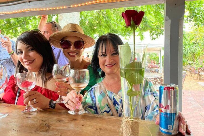 People sitting at an outdoor table with drinks and a can of Red Bull. 2