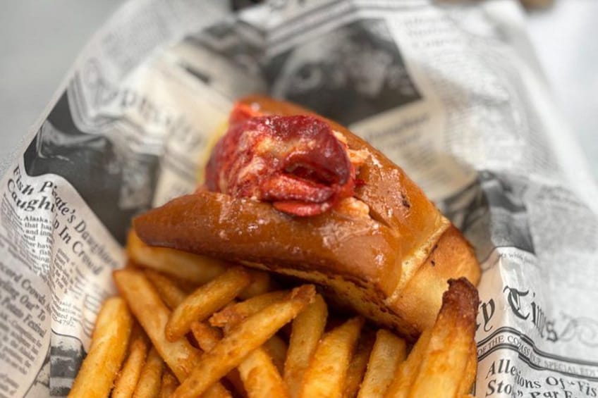 Fiskesandwich med pommes frites på avispapir. 4