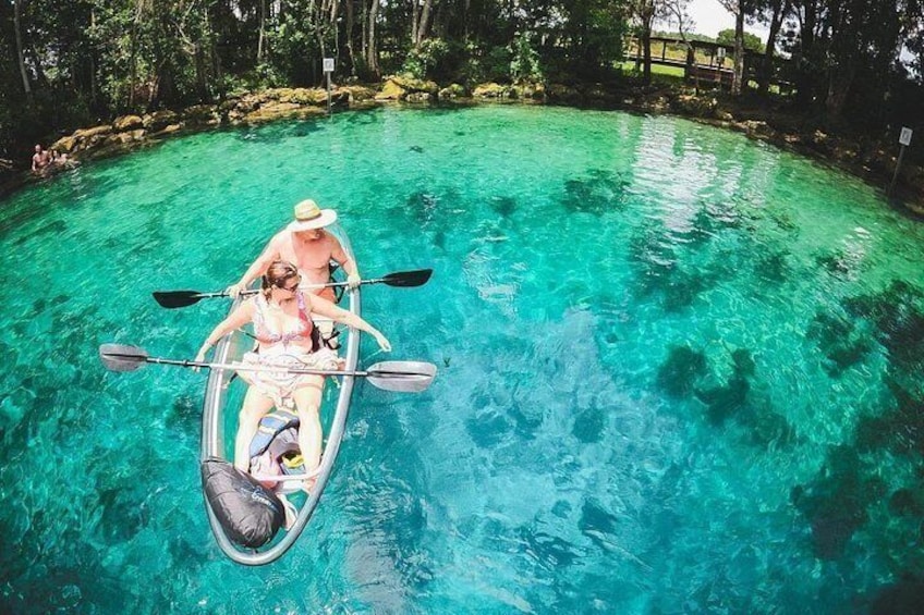A clear turquoise pool with people paddling in a small boat. 3