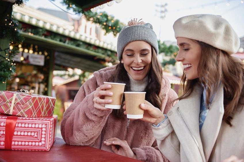 Two people sitting at a table with a gift box and a cup. 1