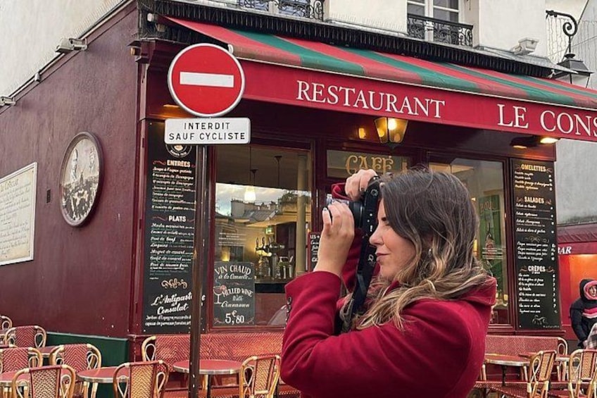 A woman taking a photo in front of a restaurant named 'RESTAURANT LE CONS.' 3