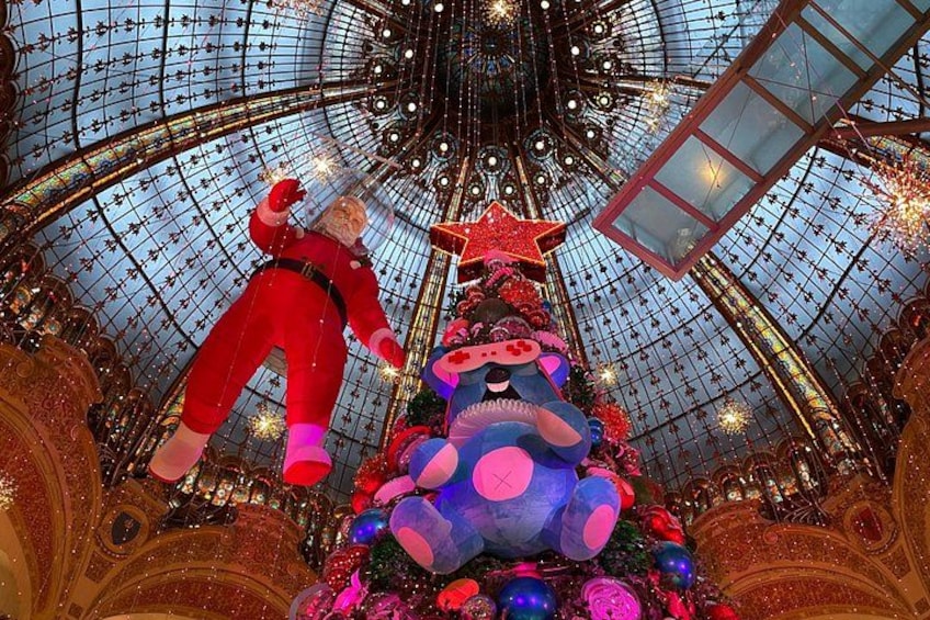 A large indoor space with a glass ceiling, a Christmas tree, and a Santa Claus figure. 2